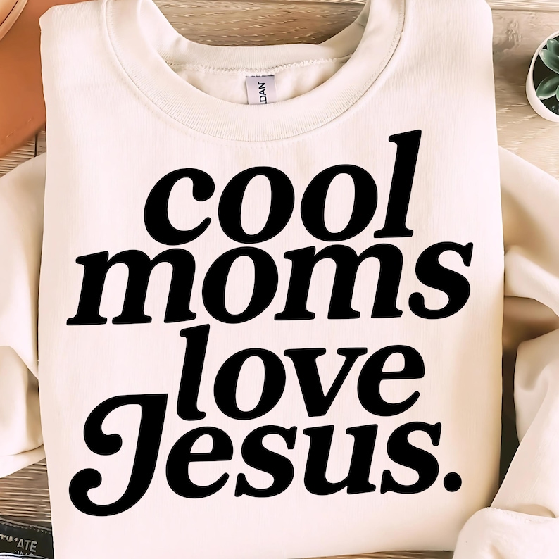 K&ouml;nnte beinhalten: Cremefarbenes Sweatshirt mit dem Text "cool moms love Jesus" in fetter, schwarzer Schrift. Das Sweatshirt mit Rundhalsausschnitt ist aus einem weichen Material gefertigt. Ein l&auml;ssiges Oberteil f&uuml;r den Alltag.