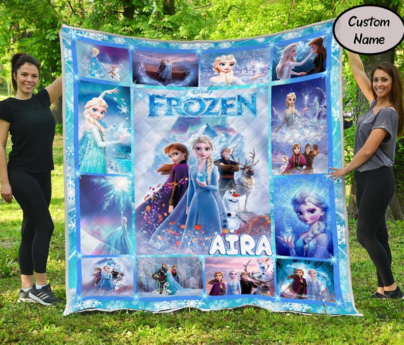 以下が含まれることがあります： ディズニー映画「アナと雪の女王」のシーンとキャラクターが描かれた、長方形の大きなキルト。キルトは青と白を基調とし、エルサ、アナ、オラフなどのキャラクターの画像が描かれています。「Aira」という名前がキルトにプリントされています。