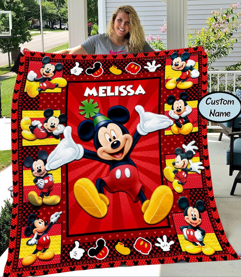 Puede incluir: Una manta roja y negra con el tema de Mickey Mouse. La manta presenta m&uacute;ltiples im&aacute;genes de Mickey Mouse en varias poses, con el nombre "MELISSA" en letras blancas. El borde tiene iconos de Mickey Mouse y una opci&oacute;n de "Nombre personalizado".