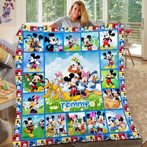 Könnte beinhalten: Eine farbenfrohe Steppdecke mit verschiedenen Bildern von Mickey Mouse und seinen Freunden. Die Decke hat einen blauen Rand mit Mickey Mouse-Symbolen und ein zentrales Feld mit dem Namen "Tommy". Das Design ist eine Mischung aus Farben und Cartoon-Figuren.