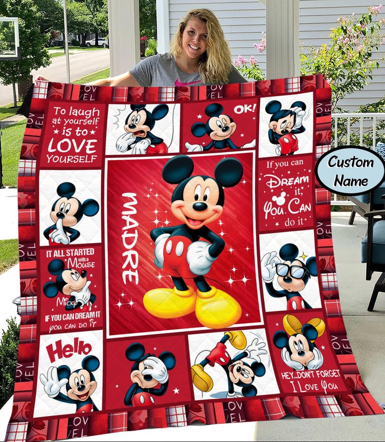 Puede incluir: Una colcha roja y blanca con el tema de Mickey Mouse. La colcha presenta varias im&aacute;genes de Mickey Mouse, junto con texto que dice "To laugh at yourself is to love yourself", "If you can dream it, you can do it" y "Hello".