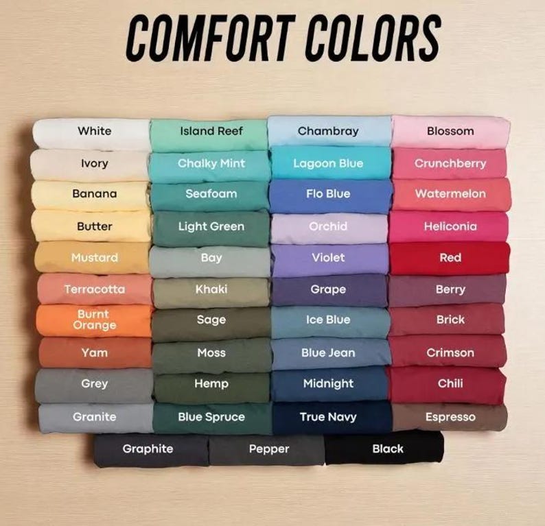 May include: A color chart displaying a variety of fabric swatches in a range of hues, including white, ivory, and black. The text "COMFORT COLORS" is at the top. Each color is labeled with its name, such as "Blossom" and "Espresso".