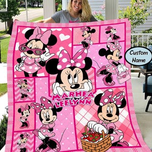 Puede incluir: Un edred&oacute;n rosa de Minnie Mouse con m&uacute;ltiples im&aacute;genes de Minnie en varias poses, sobre un fondo rosa con lunares blancos y corazones. El edred&oacute;n tiene un nombre personalizado en el centro. El edred&oacute;n est&aacute; hecho de un material suave.