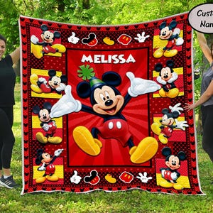 Puede incluir: Una manta roja y negra de Mickey Mouse con el nombre "MELISSA" en blanco. La manta presenta m&uacute;ltiples im&aacute;genes de Mickey Mouse en varias poses. El borde tiene iconos de Mickey Mouse.