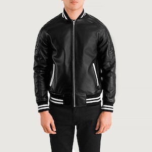 May include: Black leather bomber jacket with white stripes on the collar, cuffs, and hem. The jacket has a zip-up front and white stripes down the sides. The jacket has a quilted design on the shoulders.