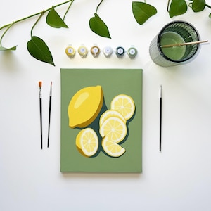 May include: A paint-by-numbers kit featuring a rectangular canvas with a printed illustration of one whole yellow lemon and several sliced lemon segments against a solid sage green background, accompanied by six numbered paint pots and three brushes.