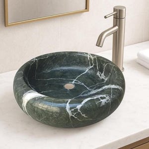 Peut inclure: Un lavabo en marbre vert avec des veines blanches. Le lavabo est rond et a une finition lisse et polie.