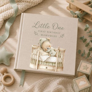 Baby memory book mockup featuring a sleeping sage green teddy bear in a wooden crib, designed for first birthday keepsake albums, nursery gifts and personalised baby photo books.