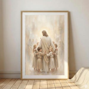 Puede incluir: Impresión enmarcada de una escena religiosa. Una figura con túnicas blancas está con un grupo de niños, todos con vestimenta similar. La obra de arte tiene una calidad suave y etérea con una luz cálida y dorada que emana de detrás de la figura central.