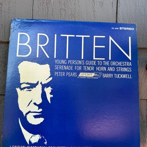 Peut inclure: Une pochette de disque vinyle bleue avec le portrait en silhouette blanche d'un homme. Le texte indique BRITTEN, YOUNG PERSON'S GUIDE TO THE ORCHESTRA, SERENADE FOR TENOR HORN AND STRINGS, PETER PEARS, LONDON ffrr, BARRY TUCKWELL et LONDON SYMPHONY ORCHESTRA CONDUCTED BY BENJAMIN BRITTEN.