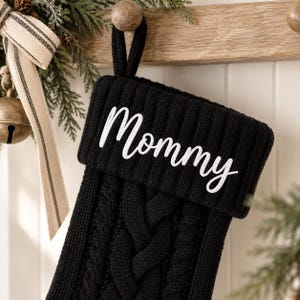 Svarta familjejulstrumpor med lantligamotiv, broderade familjejulstrumpor, babystrumpor i present, dekoration till öppen spis