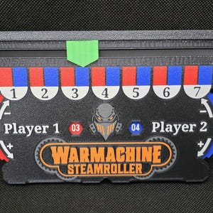May include: Black and gray Warmachine Steamroller game board with red, blue, and white accents. Features player indicators, numbered sections, and the game's logo. Includes a green arrow and a mechanical character graphic.