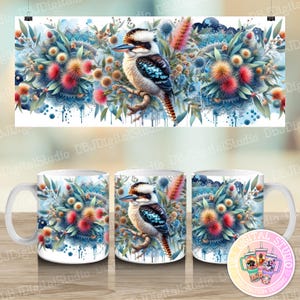 May include: A white ceramic mug with a colourful design featuring a kookaburra bird perched on a branch surrounded by blue, green and pink flowers. The design is reminiscent of a watercolour painting.