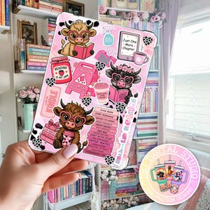 May include: A pink tablet case featuring cartoon cows with heart-shaped glasses, reading books, and holding coffee cups. The case has various stickers with book-related themes, including the text "Reading is my jam" and "Just One More Chapter."