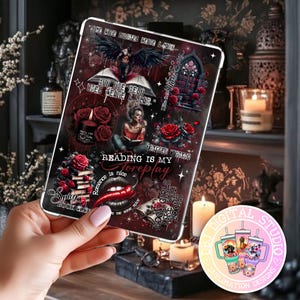Könnte beinhalten: Eine dunkelrote Tablet-Hülle mit Gothic-Thema, mit Illustrationen von Rosen, einer lesenden Frau und Text wie "Reading is my foreplay". Die Hülle hat einen weißen Rand und wird von einer Hand gehalten.