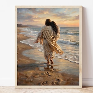 May include: A framed painting depicts a figure carrying another figure along a beach at sunset. The figures are dressed in flowing robes. Footprints are visible in the sand. The sky is filled with warm colors, and the ocean waves are gently rolling.