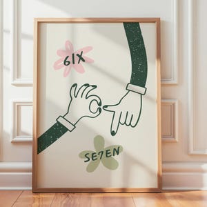 Puede incluir: Una impresión artística enmarcada con una ilustración de dos manos con mangas verde oscuro y esmalte de uñas negro. La impresión incluye el texto "6IX" y "SE7EN" con acentos florales en rosa y verde. La obra de arte está en un marco de madera.
