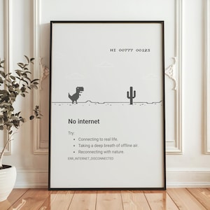 May include: A framed black and white print featuring a pixelated dinosaur, cactus, and text that reads "No internet." The print includes suggestions to connect to real life, breathe offline air, and reconnect with nature.