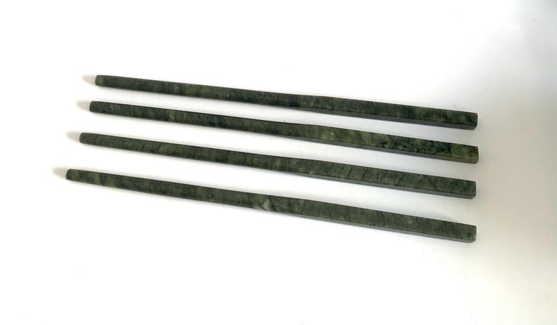 K&ouml;nnte beinhalten: Satz mit vier gr&uuml;nen Marmor-Essst&auml;bchen. Die Essst&auml;bchen sind glatt und poliert, mit einer nat&uuml;rlichen gr&uuml;nen Farbe und subtilen Maserungen.
