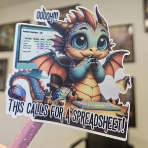 May include: A colorful sticker featuring a cartoon dragon with blue and orange wings, sitting at a desk with a computer. The text "THIS CALLS FOR A SPREADSHEET!" is displayed below the dragon, with "Ooooh!!!" above.