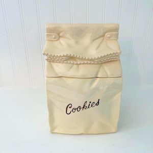 Puede incluir: Un juego de tres tazas de cerámica con un acabado mate moteado. Las tazas son de color crema, gris claro y gris oscuro. Cada taza tiene un diseño simple y minimalista y un asa redondeada.