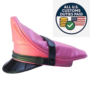 May include: A pink leather hat with a black visor and strap. The hat has a unique, angled design. The image also includes a circular graphic with text and an American flag.
