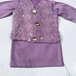 以下が含まれることがあります： 子供用の紫色の3点セット。長袖シャツ、金ボタンとスパンコールのベスト、ズボンで構成されています。