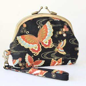 Cartera de mano con marco doble. Monedero con marco doble. Monedero de 3 compartimentos en color negro con mariposas naranjas, azules y doradas