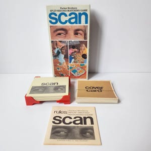 May include: A vintage Parker Brothers "Scan" split-second matching game. The box features the game's title in blue and a collage of images. Includes a stack of cards in a red holder, a "Cover Card" stack, and a rule book.