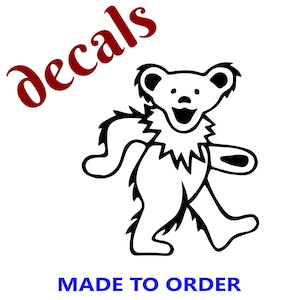 May include: Black and white bear decal with a smiling face and jagged collar. The word "decals" is in red script, and the text "MADE TO ORDER" is in blue block letters.