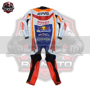 May include: A white, orange, red, blue, and black motorcycle racing suit with sponsor logos, including "REPSOL," "HONDA," and "MICHELIN." The suit features a full-body design with a zipper closure