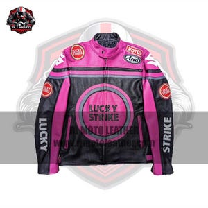 May include: A black and pink motorcycle jacket with the "Lucky Strike" logo on the front and sleeves. The jacket has a full zip, multiple patches, and the text "R.J. Moto Leather" on the bottom. The jacket is made of leather.