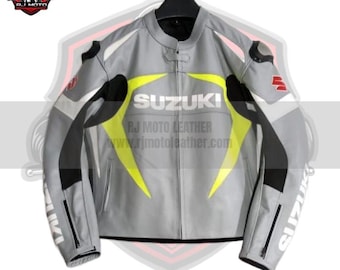May include: A gray leather motorcycle jacket with black and white accents and yellow lightning bolt designs. The jacket features the "SUZUKI" logo across the chest and "RJ MOTO LEATHER" text. The jacket has a zipper closure and is designed for motorcycle riding.