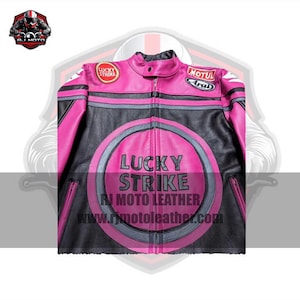 May include: Pink and black motorcycle jacket featuring the "Lucky Strike" logo. The jacket has a zip-up front, a round collar, and patches on the sleeves. The jacket has a website address printed on the front.