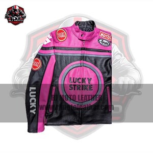 May include: A black and pink leather motorcycle jacket with the "Lucky Strike" logo. The jacket has a zip-up front, various patches, and the website address "www.tr4motoleather.com".