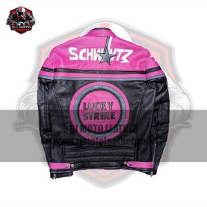 May include: Black leather motorcycle jacket with pink detailing. The back displays the word "SCHWITZ" above a star, and a "LUCKY STRIKE MOTO LEATHER" logo. The jacket has a classic biker style with a zip closure and snap details.