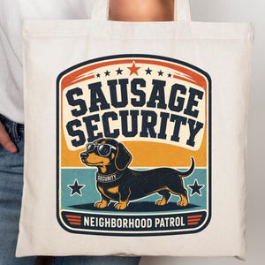 May include: A natural-colored canvas tote bag featuring a graphic print of a black and tan dachshund wearing sunglasses and a collar labeled SECURITY. The text reads SAUSAGE SECURITY and NEIGHBORHOOD PATROL in a vintage-style badge design.
