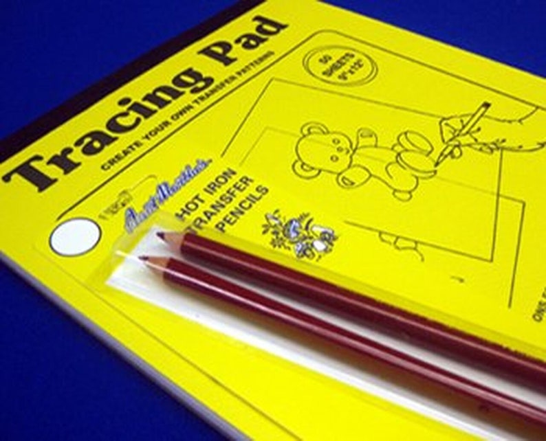 May include: A yellow tracing pad with the text "Tracing Pad" and "Create Your Own Transfer Patterns". The pad includes 50 sheets of paper. A pack of two red hot iron transfer pencils is included.