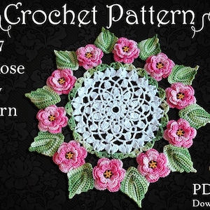 Pode incluir: Um tapete de crochê branco com um design de rosa 3D. O tapete é rodeado por rosas e folhas de crochê rosa e verde. O texto "c1957 3D Rose Doily Pattern Only #101 PDF File Downloadable" é visível na imagem.
