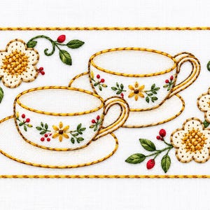 May include: A rectangular embroidery piece on white fabric featuring two white teacups and saucers with yellow rims. The design includes embroidered yellow flowers, green leaves, and small red berries arranged around the teacups.