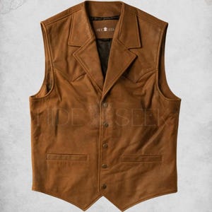 May include: A brown leather vest with a pointed collar, five buttons, and two pockets. The vest has a "Hide & Seek" logo on the front.