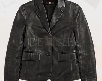 Pode incluir: Um blazer de couro preto com gola entalhada, dois bolsos frontais e fecho de um botão. O blazer tem o texto "HIDE & SEEK" na etiqueta.