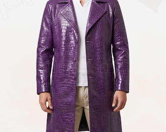 May include: A long purple coat featuring a textured crocodile skin pattern, a notched lapel, and a button-front closure. The coat is worn over a plain white V-neck shirt and light-colored trousers, showcasing a structured, knee-length silhouette.