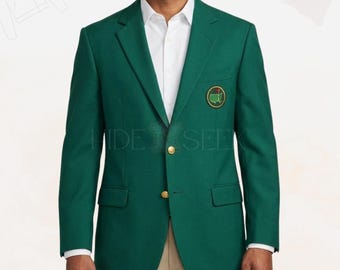 May include: A dark green blazer with a gold button closure and a small emblem on the chest. The blazer is paired with a white dress shirt and khaki pants. The blazer has a classic, tailored fit.