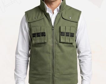 May include: Olive green vest with a high collar, two flap pockets with black buckles, and a full-length zipper. The vest is worn over a white collared shirt.