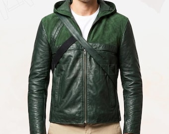 May include: A dark green leather jacket with a hood and a black strap across the chest. The jacket has a zipper closure and a quilted design on the shoulders. The model is wearing a white shirt underneath.