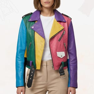 Op de afbeelding: Een veelkleurige leren jas in klassieke bikerstijl. De jas heeft panelen in blauw, groen, geel, roze en paars. Het heeft een zwarte riem, ritsen en een witte zak. De kraag is paars en de mouwen zijn lang.