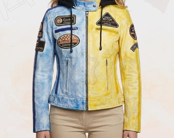 Op de afbeelding: Een tweekleurige motorjas, half lichtblauw en half geel, met een zwarte capuchon. De jas heeft meerdere patches met tekst en ontwerpen, een ritssluiting en een distressed lederlook.