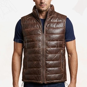 Puede incluir: Chaleco de cuero marrón con diseño acolchado y cremallera completa. El chaleco tiene cuello alto y dos bolsillos laterales. Se lleva sobre una camiseta azul marino.
