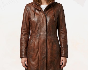 May include: A brown leather hooded coat with a full-length design. The coat features a drawstring hood, a zip-up front, and pockets. The leather has a distressed look, giving it a vintage appearance. The coat is worn by a person.